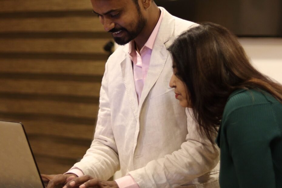 Indian business professionals collaborating on a laptop while evaluating AI tools for a small business.